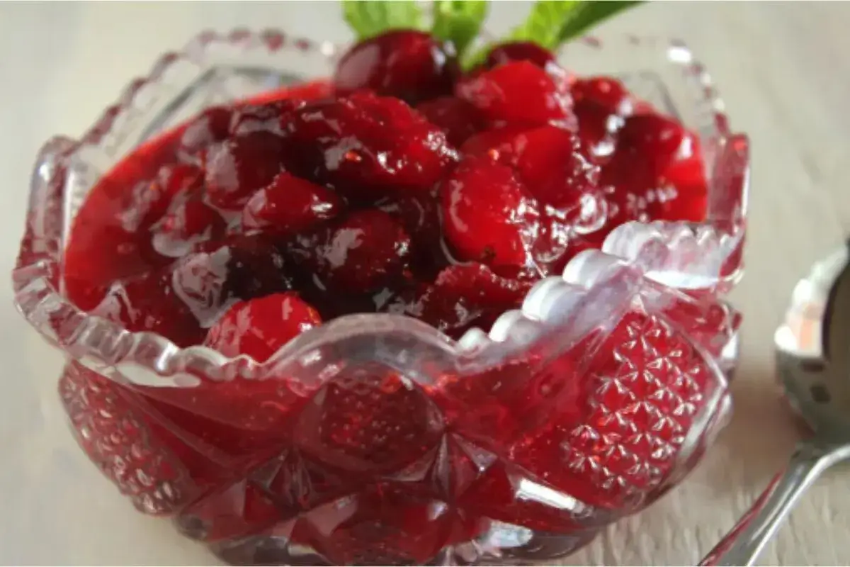 A bowl of vibrant red classic cranberry sauce with orange zest garnish