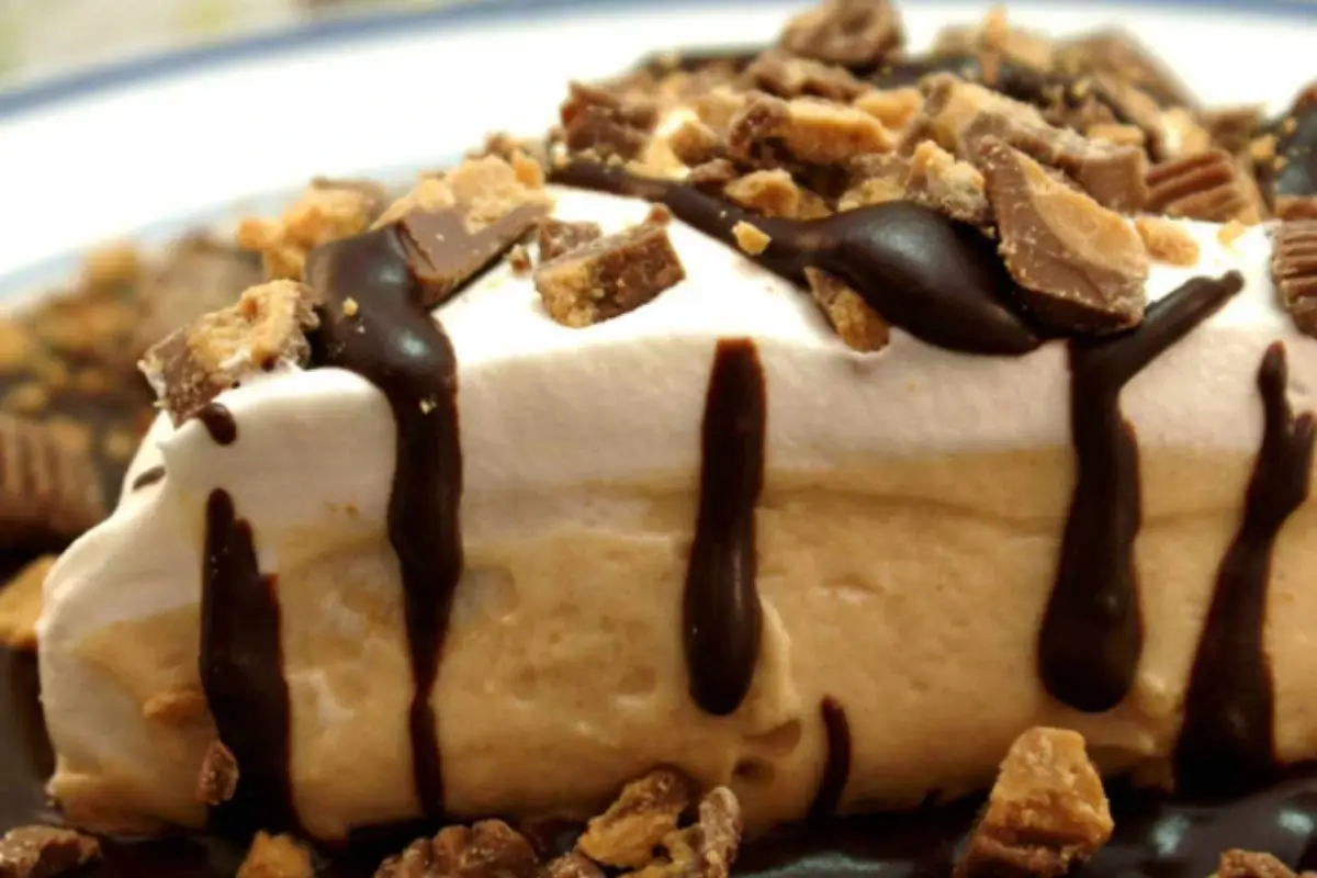 A rich slice of Amish Peanut Butter Cream Pie topped with whipped cream and chocolate shavings.