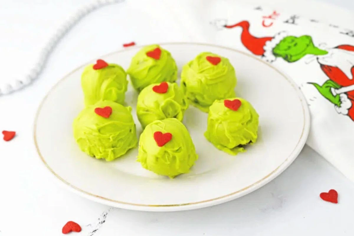 Bright green Grinch Oreo Truffles with red hearts, perfect for festive holiday desserts.